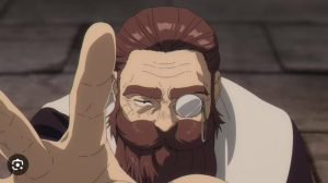 アニメ『葬送のフリーレン』より、一点を見据え右手を力強く差し出すデンケンのカット。片眼鏡（モノクル）の奥にある鋭い瞳と、人生の年輪を感じさせる額の皺が、彼の魔法使いとしての不退転の決意を象徴している。